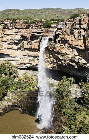 High angle view of waterfall flowing over rocky cliff View Large Photo Image Picture - High angle view of waterfall flowing over rocky cliff. Fotosearch