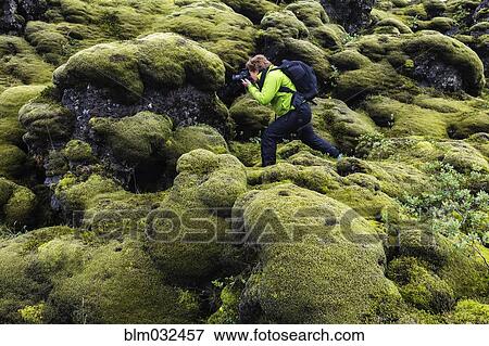 Hiker taking photograph on mossy rock formations View Large Photo Image Stock Photo - Hiker taking photograph on mossy rock formations. Fotosearch