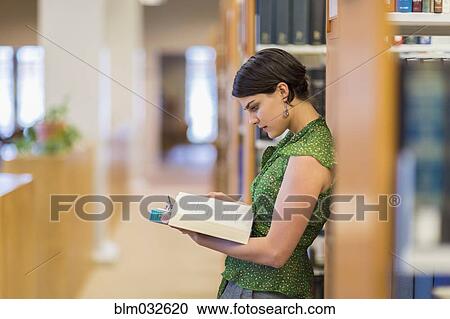 Mixed race student reading book in library View Large Photo Image Stock Image - Mixed race student reading book in library. Fotosearch