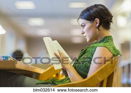 Picture - Mixed race student studying in library. Fotosearch