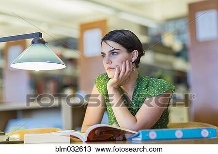 Stock Image - Mixed race student studying in library. Fotosearch
