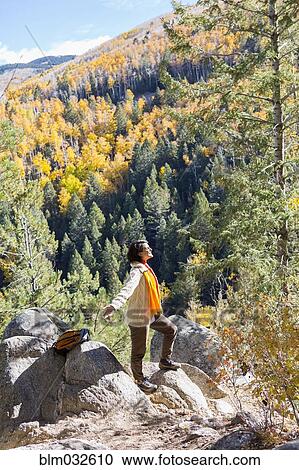 Stock Image - Mixed race woman admiring scenic view in forest. Fotosearch
