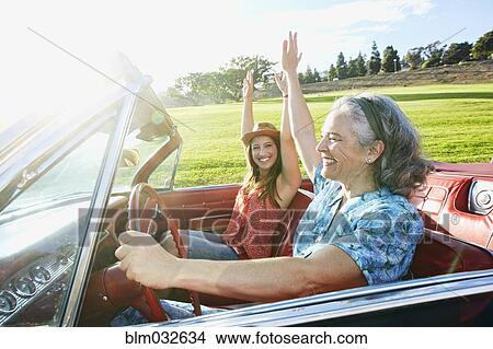 Picture - Mother and daughter driving in classic convertible. Fotosearch