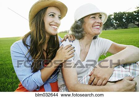 Picture - Mother and daughter smiling in park. Fotosearch