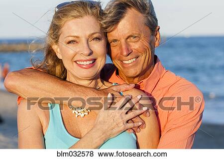Older Caucasian couple hugging on beach View Large Photo Image Stock Photo - Older Caucasian couple hugging on beach. Fotosearch