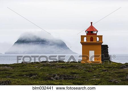 Orange lighthouse on rocky remote cliff View Large Photo Image Stock Image - Orange lighthouse on rocky remote cliff. Fotosearch