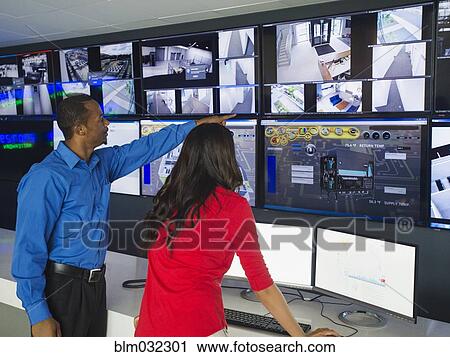 Security officers watching surveillance cameras View Large Photo Image Stock Image - Security officers watching surveillance cameras. Fotosearch