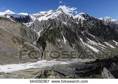 Snow covered mountains over rocky canyon road View Large Photo Image Stock Photo - Snow covered mountains over rocky canyon road. Fotosearch