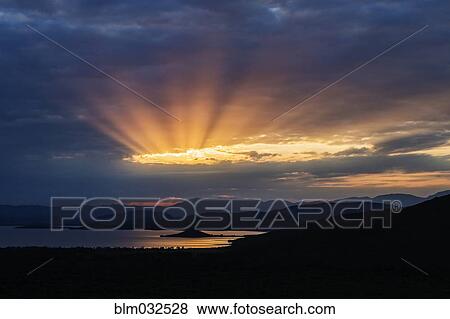 Sunbeams in cloudy sky over remote lake View Large Photo Image Stock Photo - Sunbeams in cloudy sky over remote lake. Fotosearch