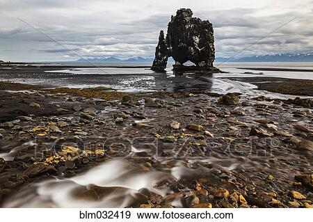 Water flowing over rocks on beach towards Hvitserkur Rock, Hvammstangi, Iceland View Large Photo Image Stock Photo - Water flowing over rocks on beach towards Hvitserkur Rock, Hvammstangi, Iceland. Fotosearch