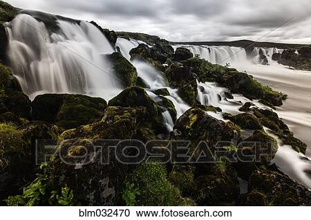 Waterfall pouring over rock formations in remote river View Large Photo Image Stock Image - Waterfall pouring over rock formations in remote river. Fotosearch