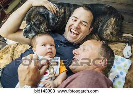 コーカサス人 ゲイカップル 抱きしめること 男の赤ん坊 そして 犬 ストックイメージ Bld Fotosearch