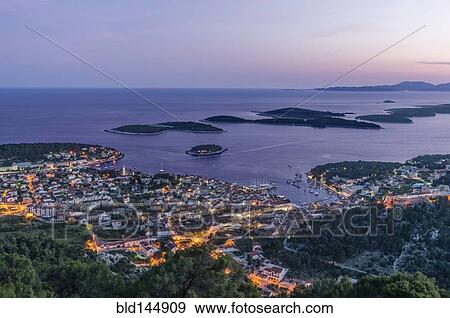 Stock Photo - Aerial view of coastal town illuminated at night. Fotosearch