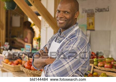Picture - African American vendor smiling at farmers market. Fotosearch
