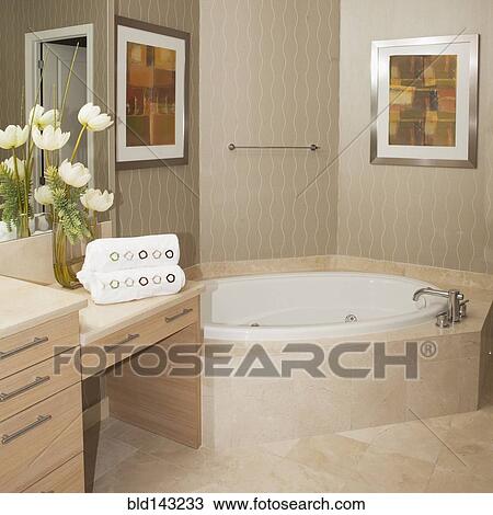 Stock Image - Bathtub, wall art and countertops in bathroom. Fotosearch
