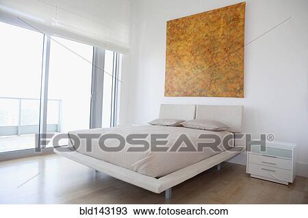 Stock Image - Bed and night table in modern bedroom. Fotosearch