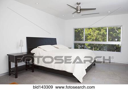 Bed, night table and window in modern bedroom View Large Photo Image Stock Photo - Bed, night table and window in modern bedroom. Fotosearch
