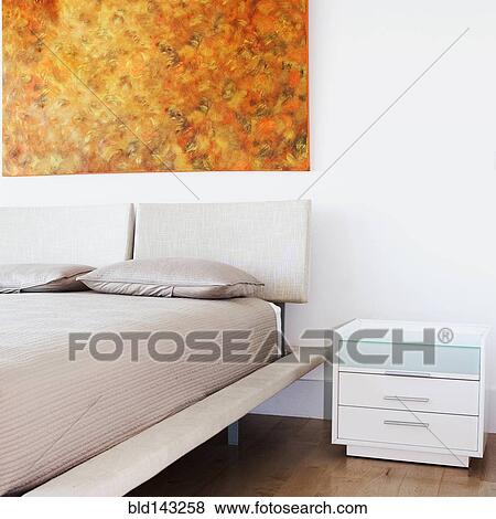 Bed, wall art and side table in modern bedroom View Large Photo Image Stock Photo - Bed, wall art and side table in modern bedroom. Fotosearch