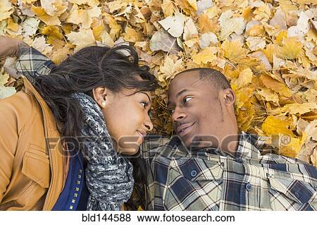 Black couple laying together in autumn leaves View Large Photo Image Stock Photo - Black couple laying together in autumn leaves. Fotosearch