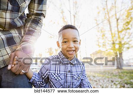 Black father and son walking in autumn leaves View Large Photo Image Stock Photo - Black father and son walking in autumn leaves. Fotosearch