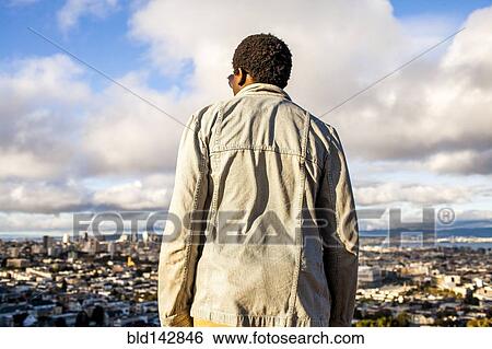 Black man looking at scenic view of cityscape View Large Photo Image Stock Photograph - Black man looking at scenic view of cityscape. Fotosearch