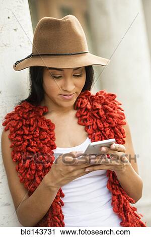 Stock Image - Black woman using cell phone outdoors. Fotosearch