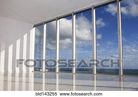 Stock Photography - Blue sky viewed through windows in modern apartment. Fotosearch