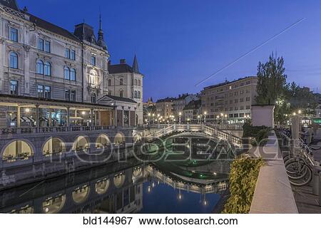 Stock Photo - Buildings and pedestrian bridge over urban canal, Ljubljana, Central Slovenia, Slovenia. Fotosearch