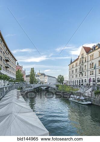 Stock Photography - Buildings and pedestrian bridge over urban canal, Ljubljana, Central Slovenia, Slovenia. Fotosearch
