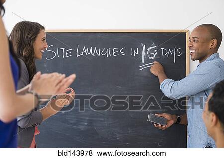 Stock Photo - Business people cheering and gearing up for site launch in office. Fotosearch