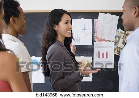 Stock Photo - Business people examining presentation in meeting. Fotosearch