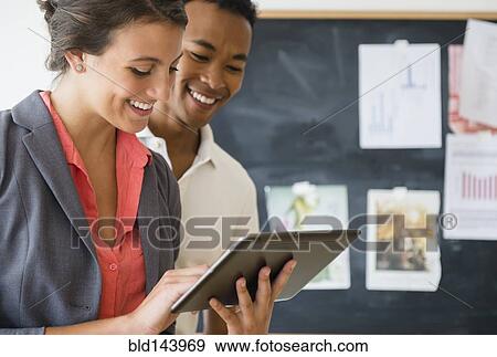 Stock Photo - Business people using digital tablet in office. Fotosearch