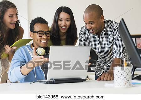 Stock Photography - Business people working together on laptop in office. Fotosearch