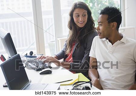 Stock Photography - Business people working together on computer in office. Fotosearch