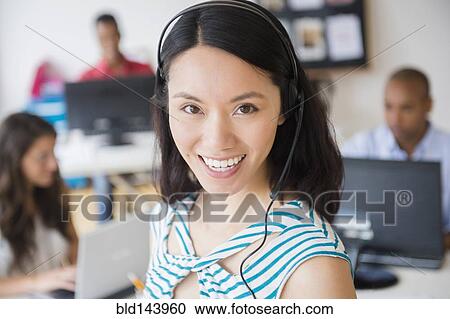 Businesswoman wearing headset in office View Large Photo Image Stock Image - Businesswoman wearing headset in office. Fotosearch