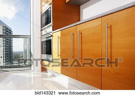 Stock Image - Cabinets, ovens and windows in modern kitchen. Fotosearch