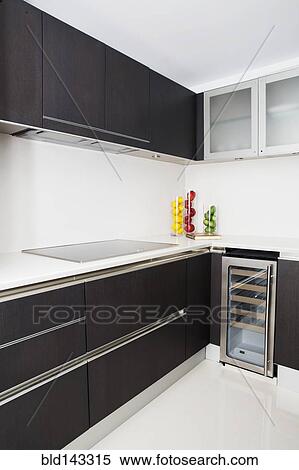 Stock Photography - Cabinets, stove and miniature refrigerator in modern kitchen. Fotosearch