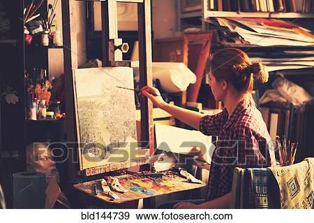 Stock Photo - Caucasian artist painting on canvas in studio. Fotosearch