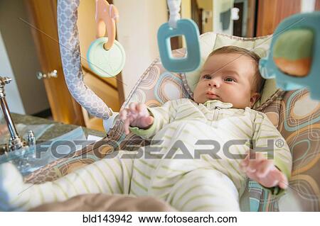 Stock Image - Caucasian baby admiring mobile. Fotosearch
