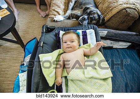 Picture - Caucasian baby boy laying on crib. Fotosearch