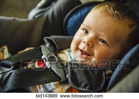 Stock Photo - Caucasian baby boy smiling in car seat. Fotosearch