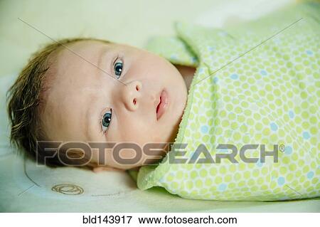 Stock Photo - Caucasian baby boy swaddled in blanket. Fotosearch