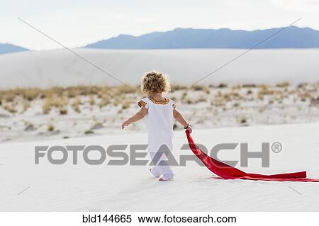 Caucasian boy playing with scarf on sand dune View Large Photo Image Stock Photography - Caucasian boy playing with scarf on sand dune. Fotosearch