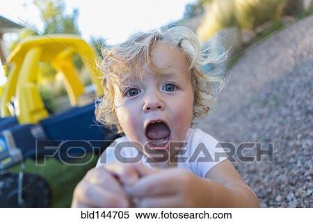 Stock Photography - Caucasian boy shouting in backyard. Fotosearch