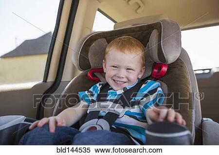 Stock Photography - Caucasian boy smiling in car seat. Fotosearch