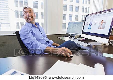 Caucasian businessman working at computer in office View Large Photo Image Stock Photography - Caucasian businessman working at computer in office. Fotosearch
