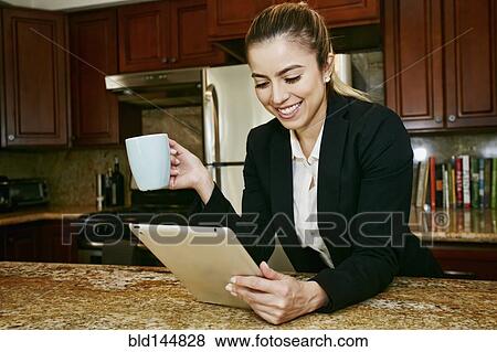 Caucasian businesswoman using digital tablet in kitchen View Large Photo Image Stock Photo - Caucasian businesswoman using digital tablet in kitchen. Fotosearch