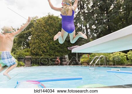 Picture - Caucasian children jumping into swimming pool. Fotosearch