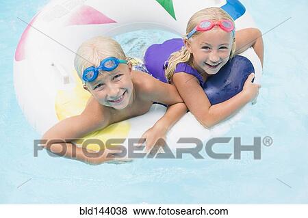 Stock Photo - Caucasian children playing in swimming pool. Fotosearch