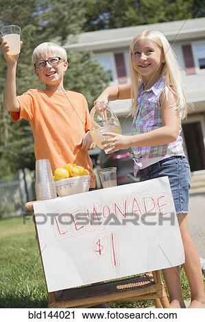 Stock Image - Caucasian children selling lemonade in front yard. Fotosearch